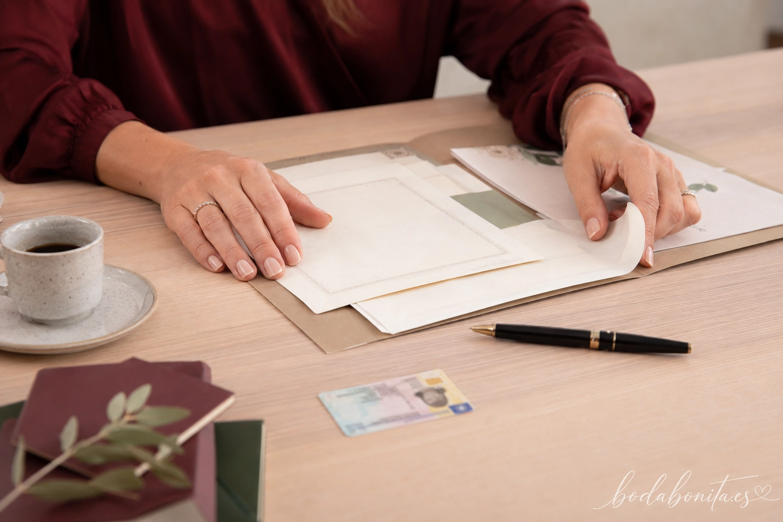 manos revisando un DNI y varios certificados dentro de una carpeta para los papeles de la boda