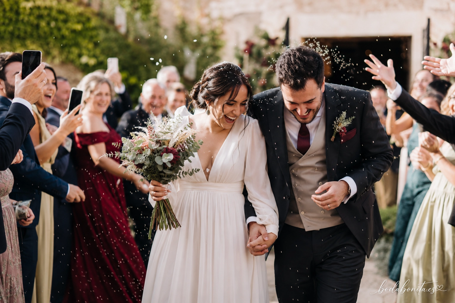 novios recién casados saliendo entre una lluvia de arroz mientras los invitados les hacen fotos con el móvil
